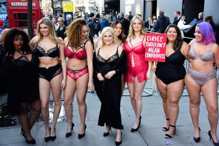 Plus-size women turn up to London Fashion Week in lingerie to protest the lack of curves